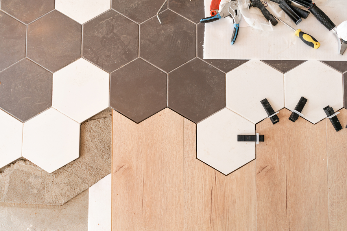 Combinatie van houten parket en tegels Combinatie van houten parket en zeshoekige tegels tijdens vloerinstallatie